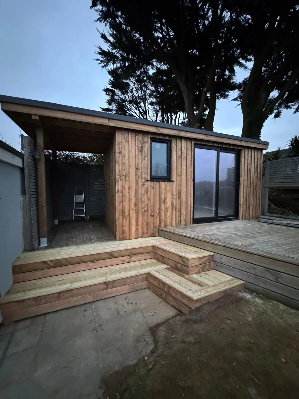 Garden office with covered storage area and timber decking