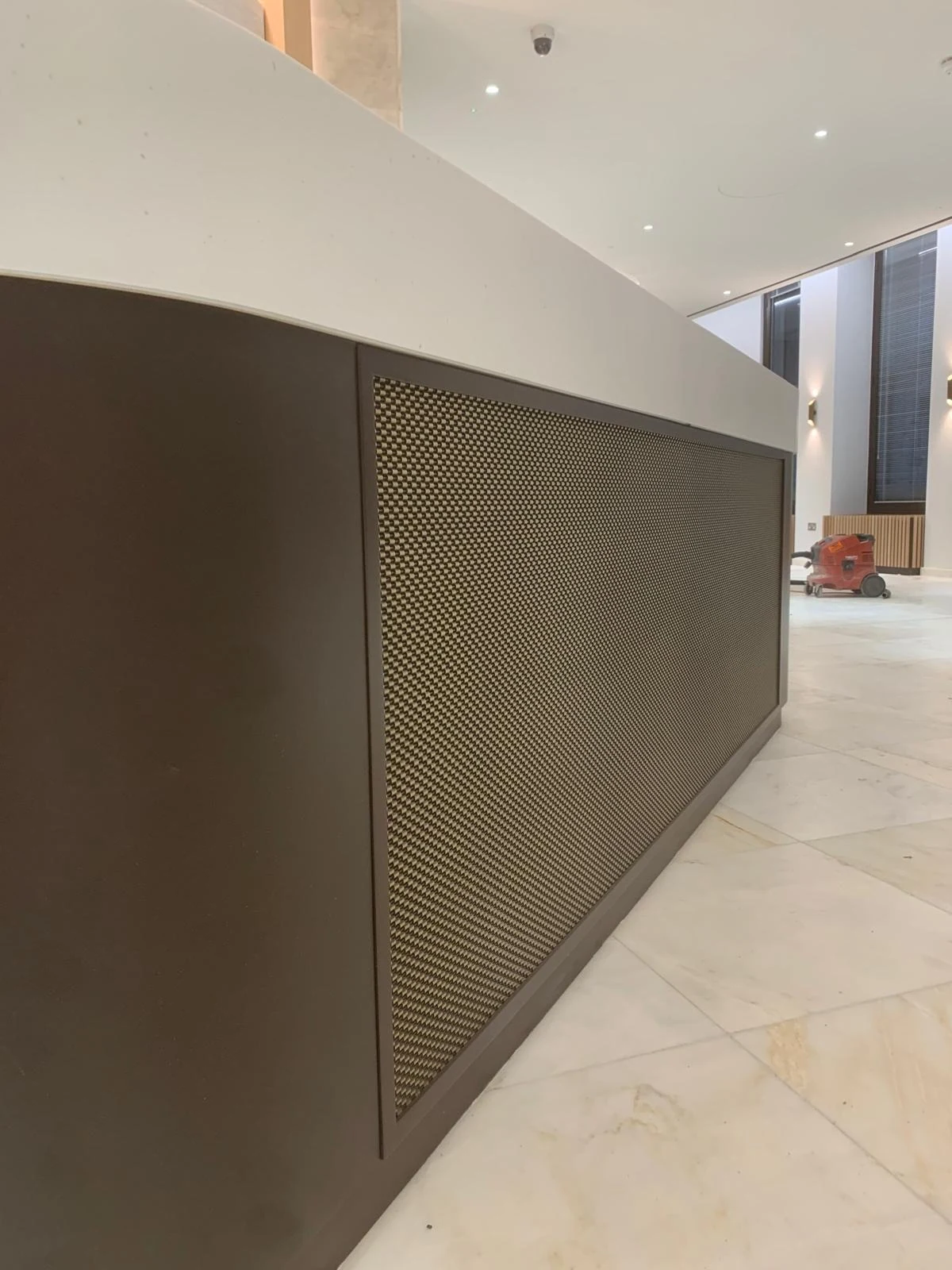 Dark timber-clad curved joinery panel with stone counter