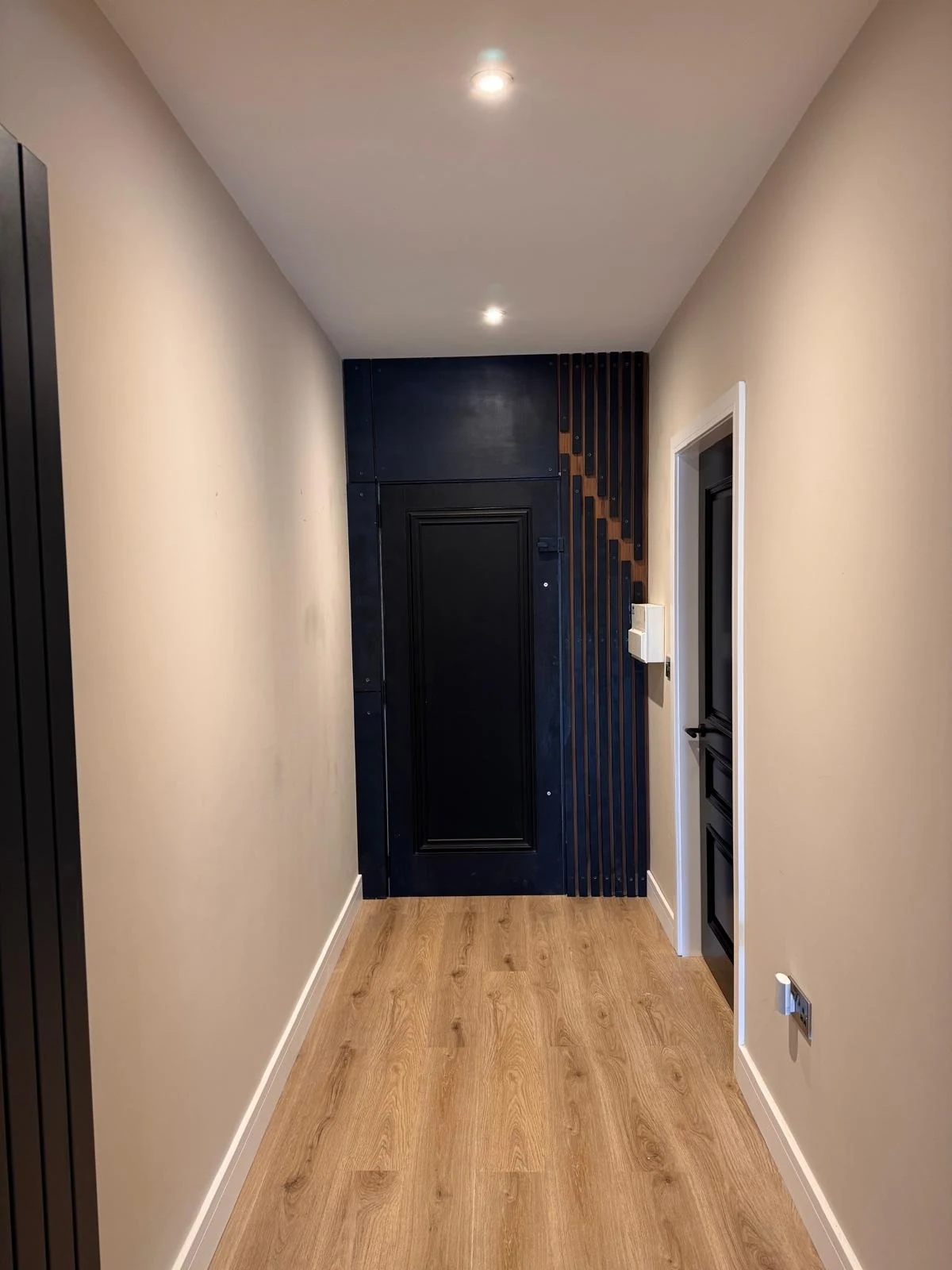Hallway with black feature panelling and staircase detail