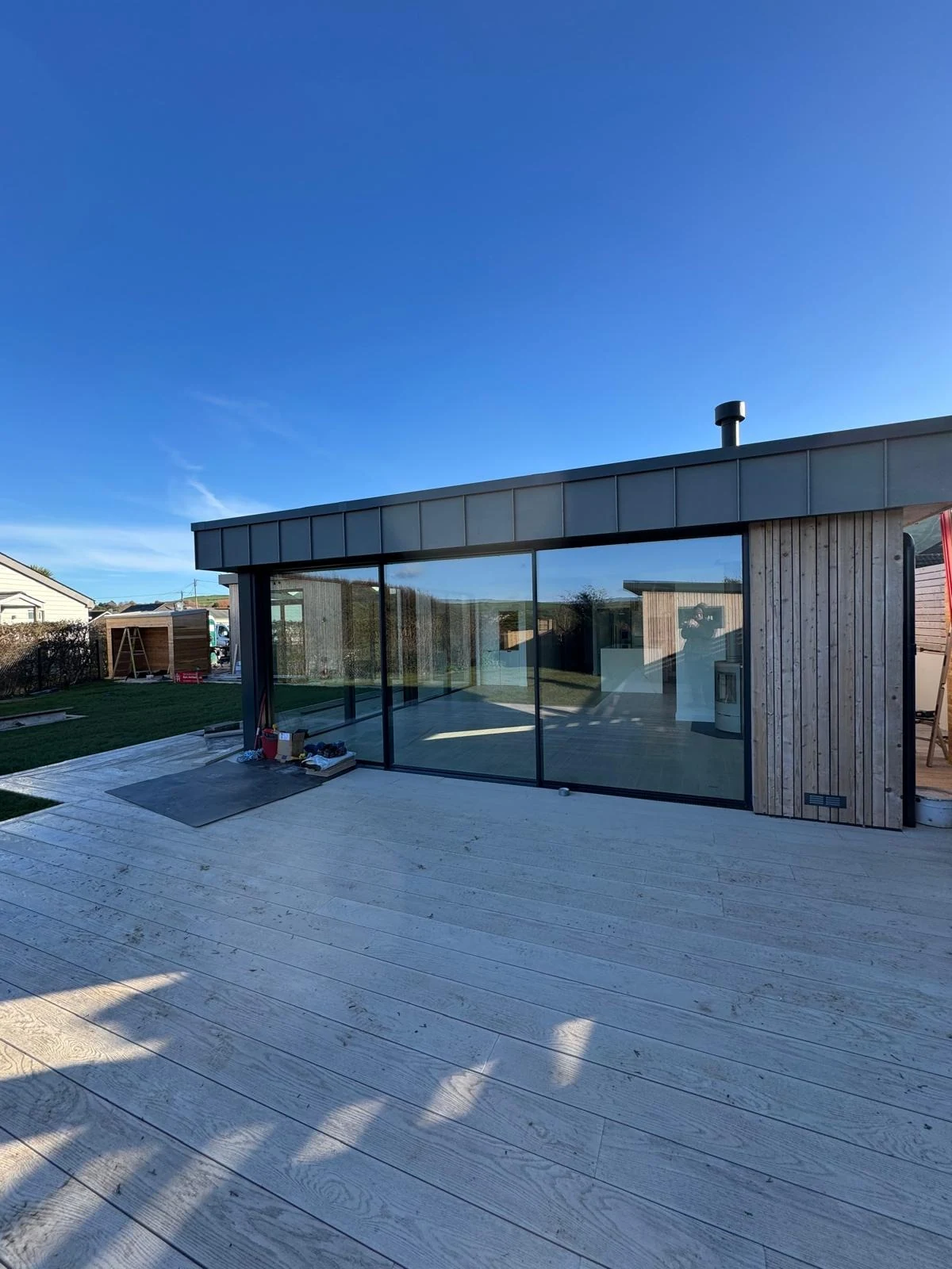 New build with timber cladding and full-width glazing onto a patio