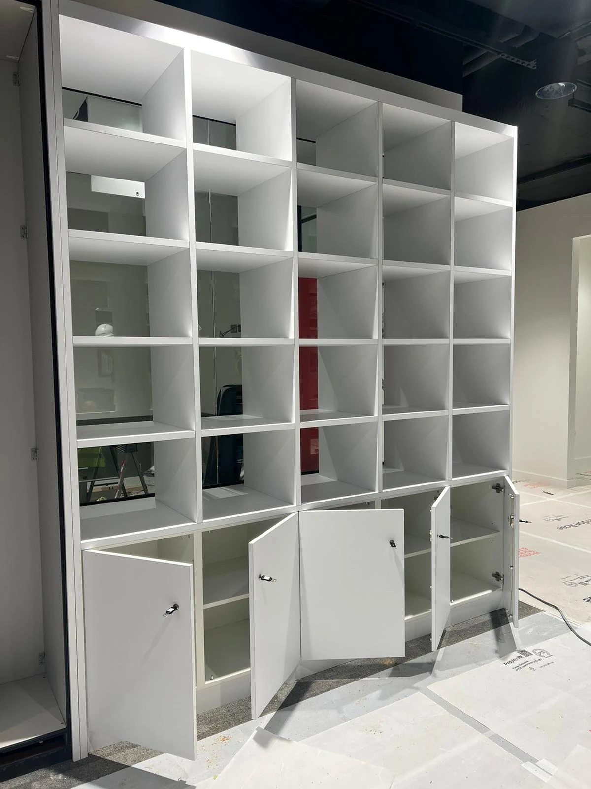 Made-to-measure white bookcase with cupboard doors, bespoke cabinetry