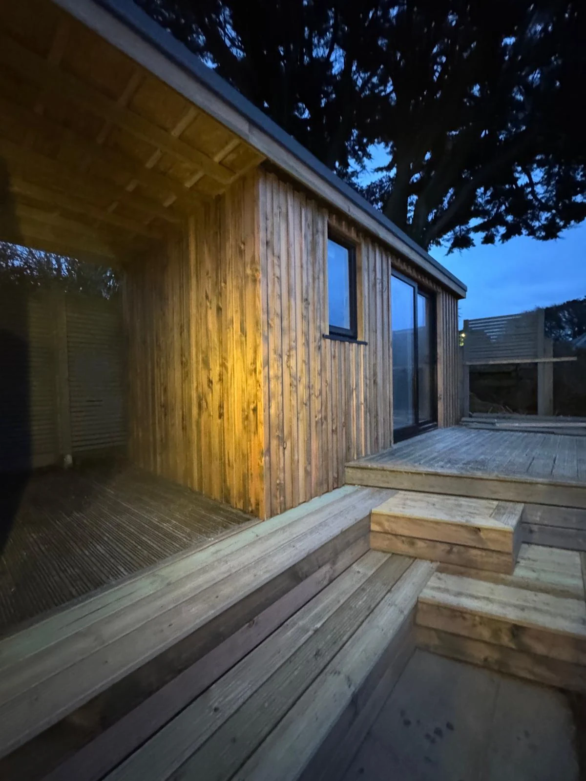 Larch-clad garden office with raised timber decking and steps