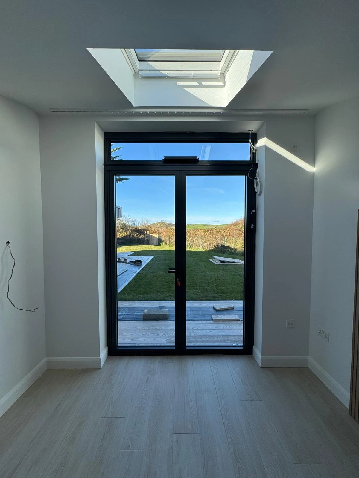 New build garden room with roof lantern and black glazed doors