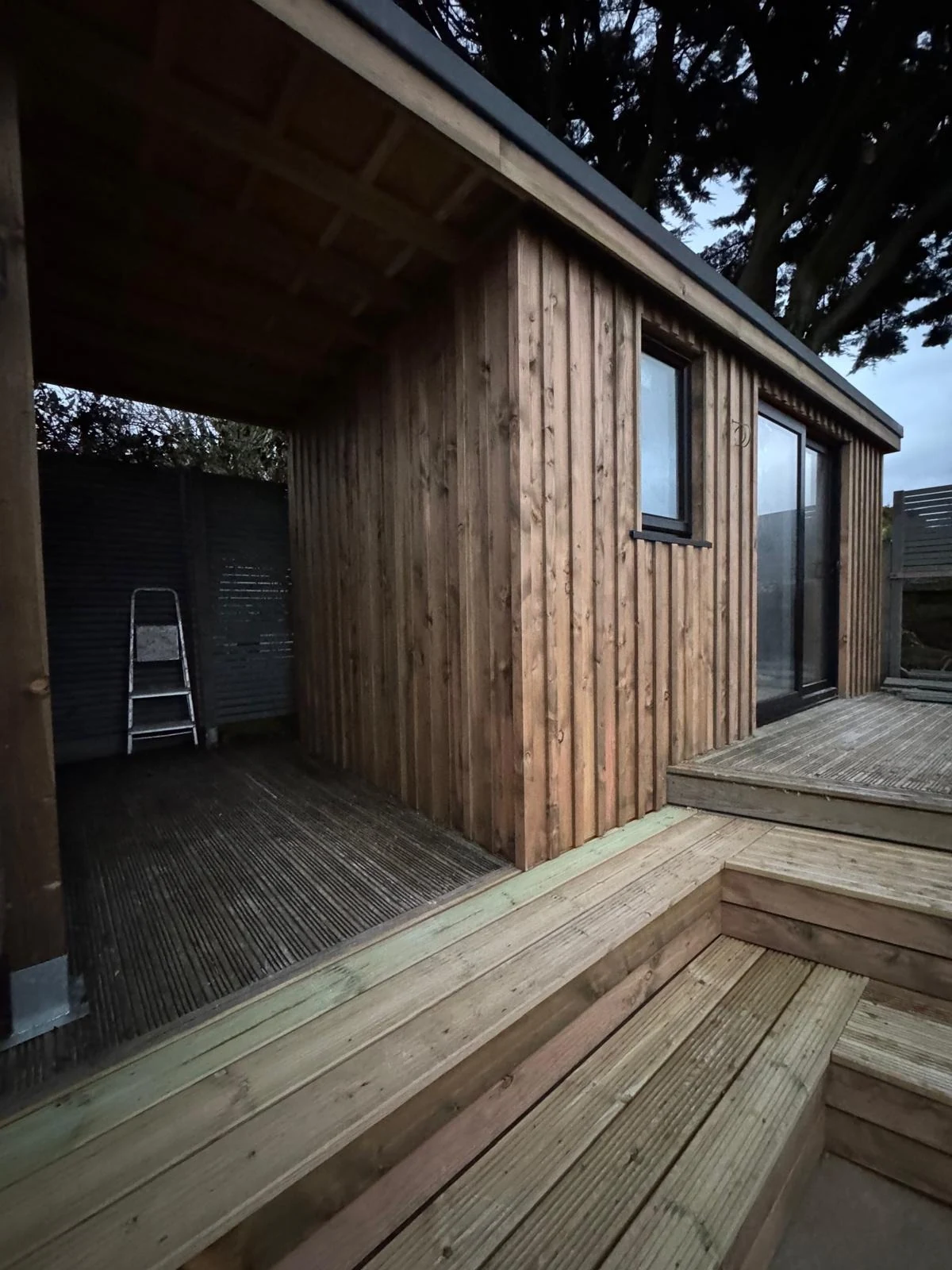 Garden office cladding and decking detail at dusk