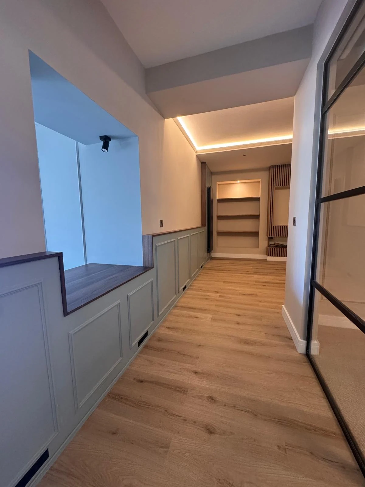 Fitted window seat and panelling in a bright corridor
