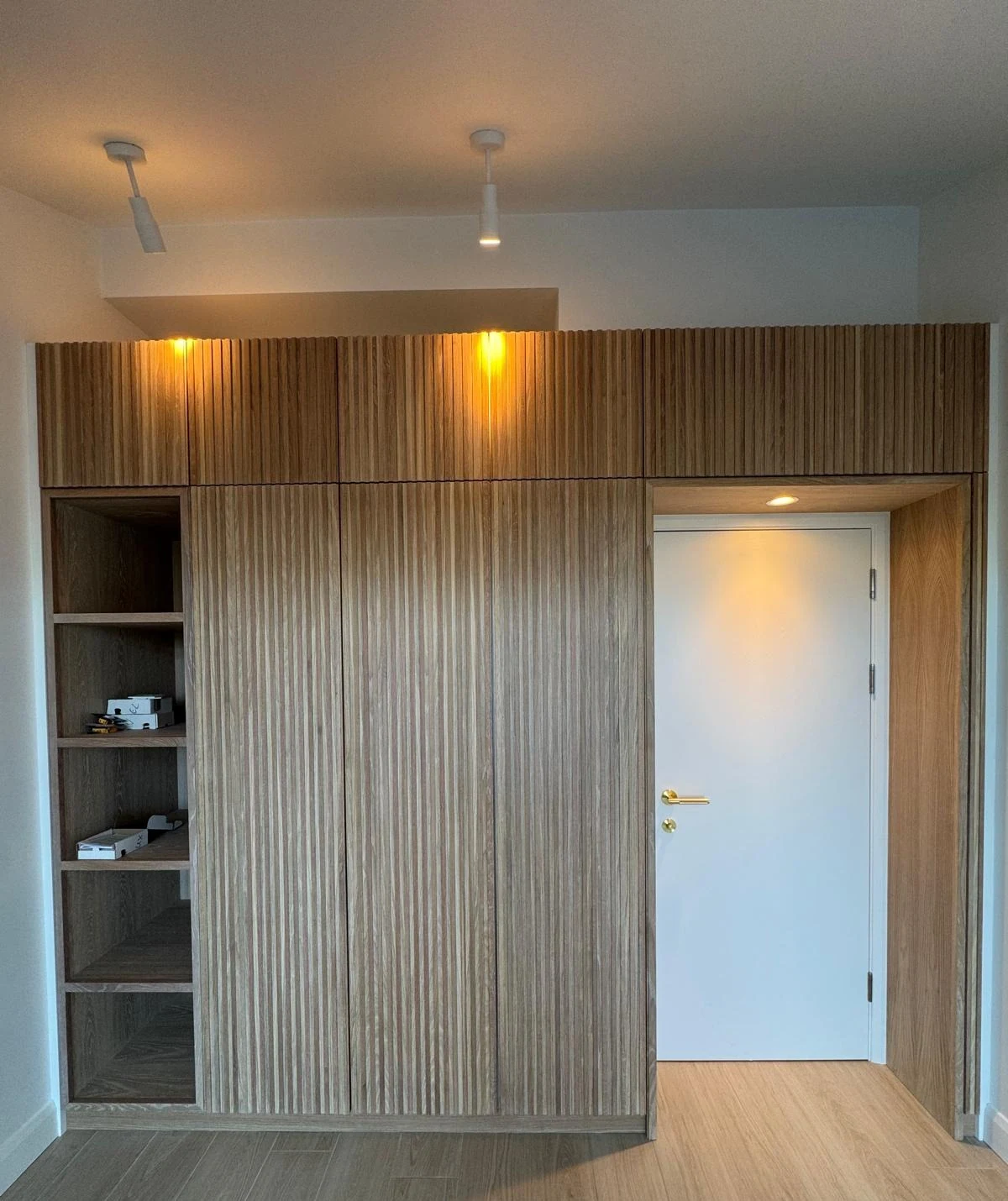 Floor-to-ceiling bespoke timber cabinetry with open shelving and downlights