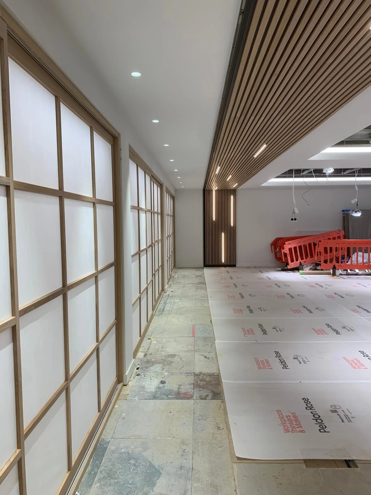 Timber slatted ceiling and screen panels along a corridor