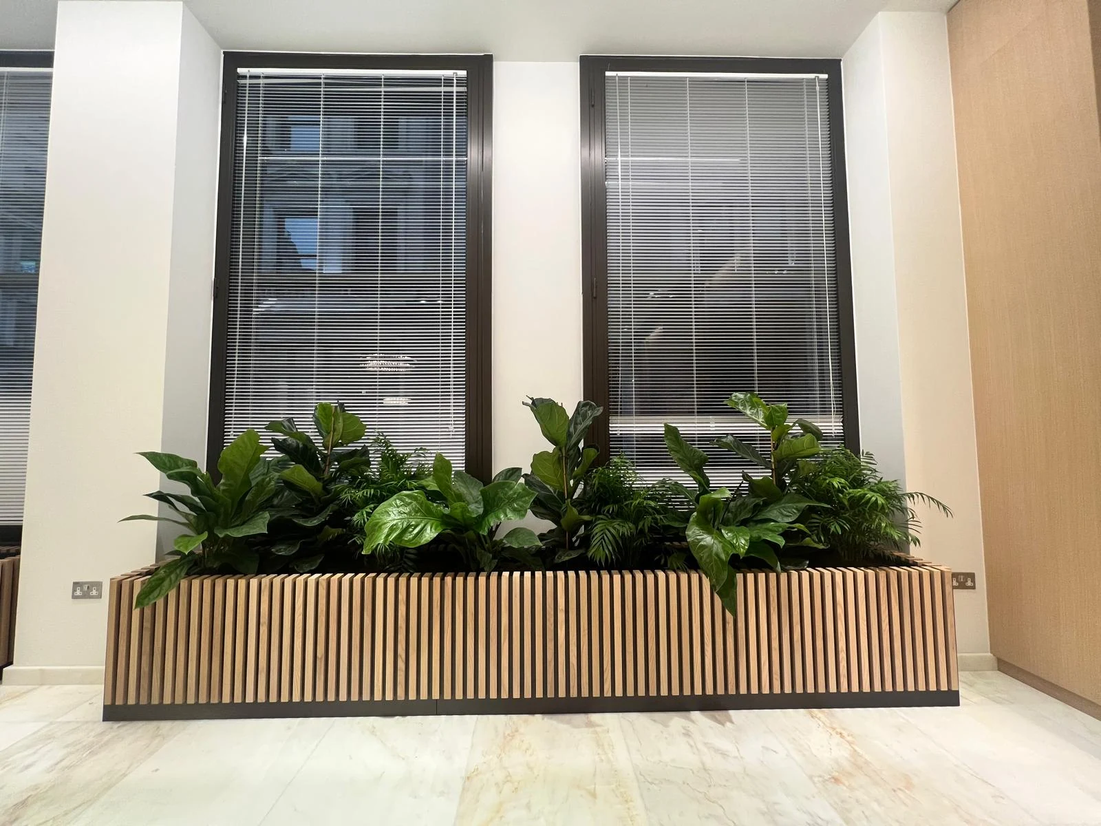 Bespoke timber planter beneath two large windows