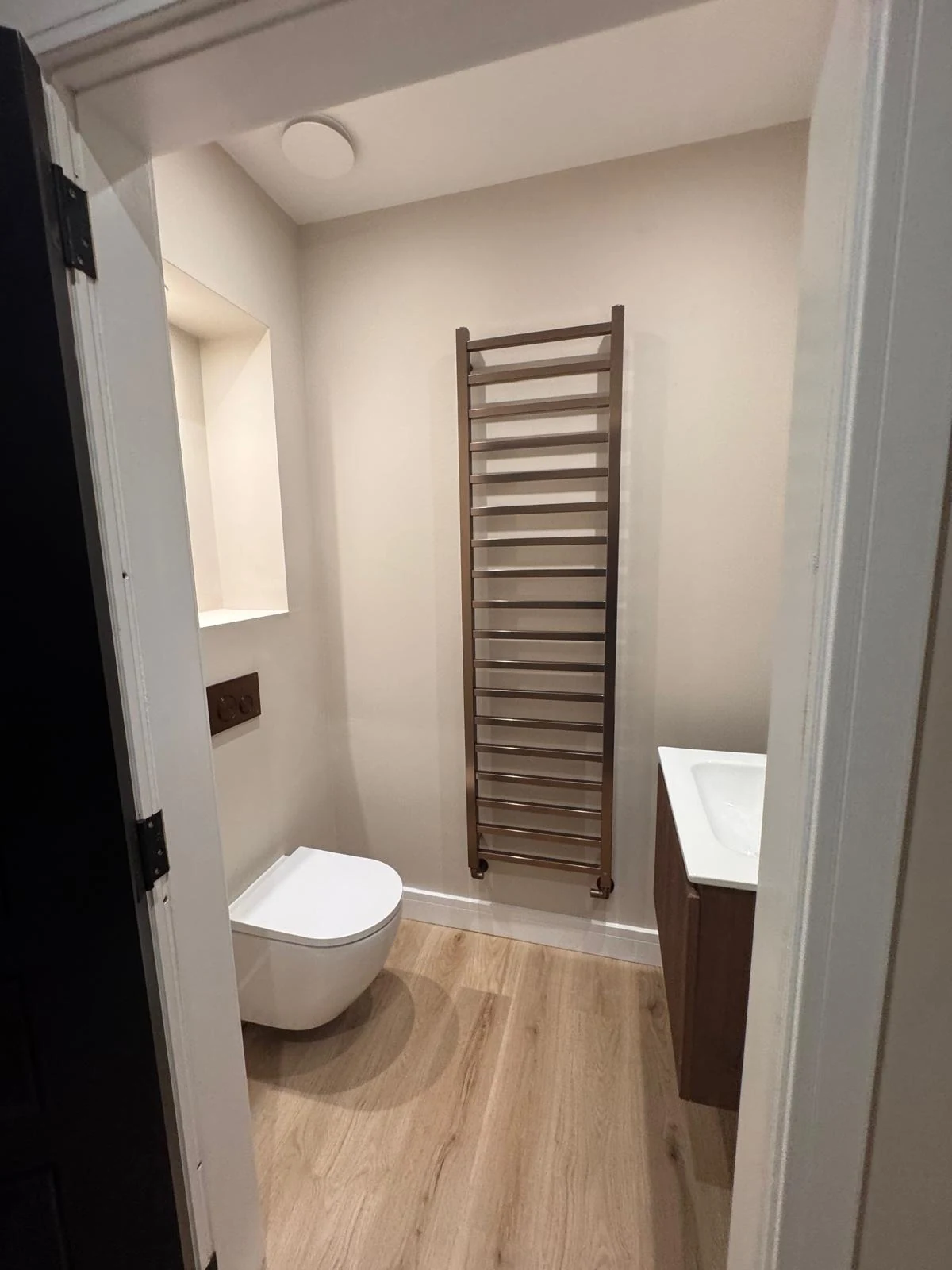 Finished bathroom renovation with towel radiator and wall-hung toilet