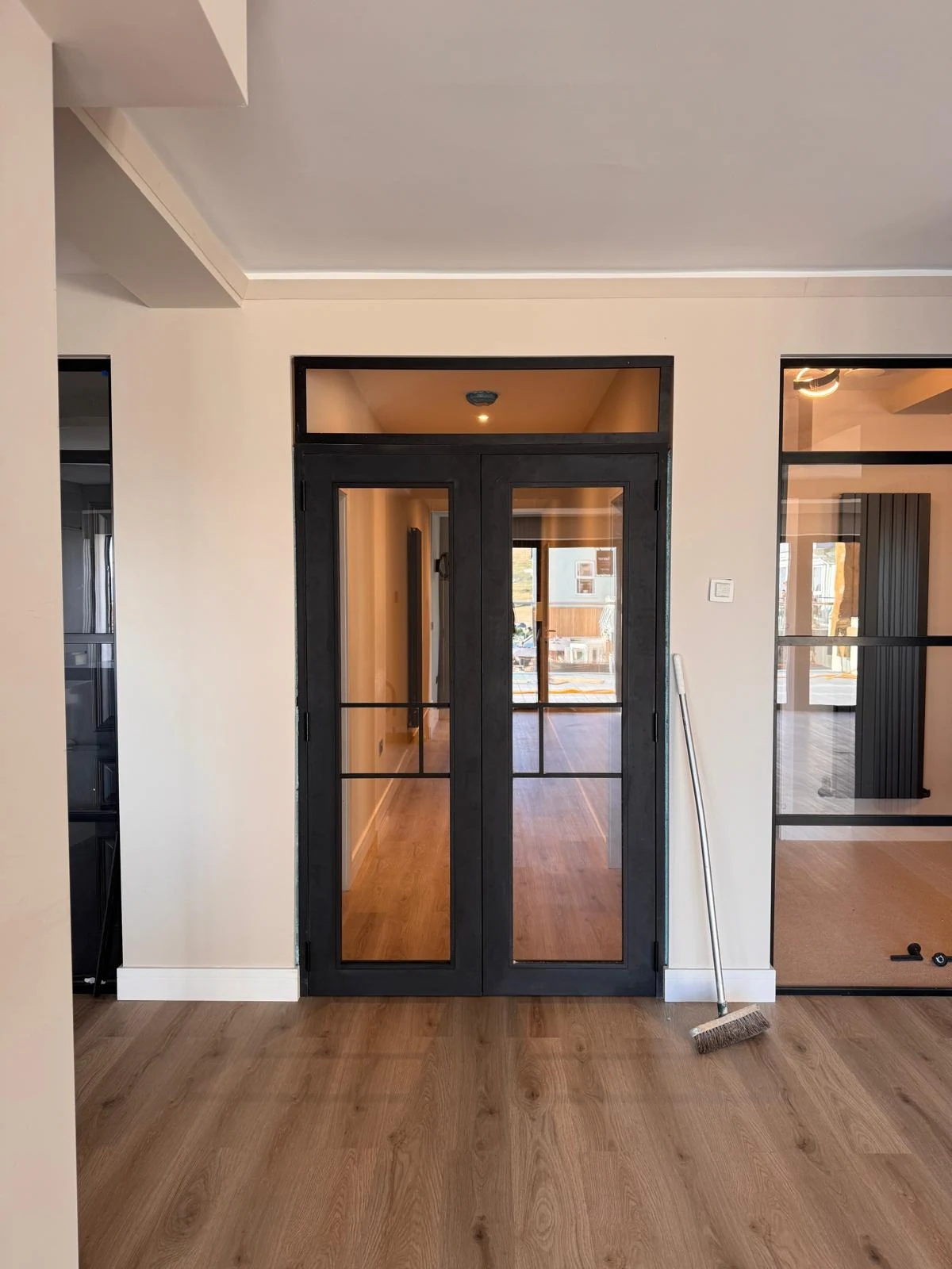 Black framed glazed double doors in a renovated interior
