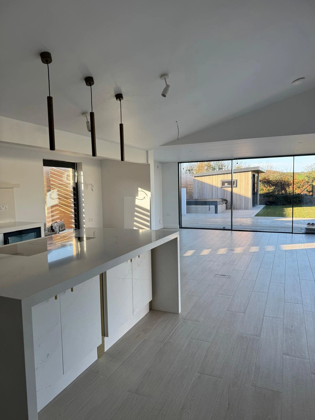 Kitchen extension with white units and garden views