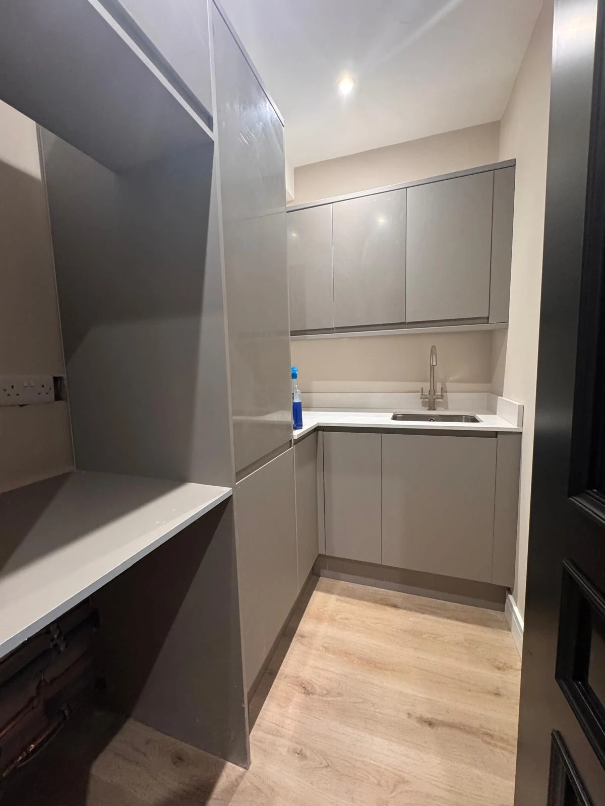 Grey handleless kitchen units with tall larder cupboards
