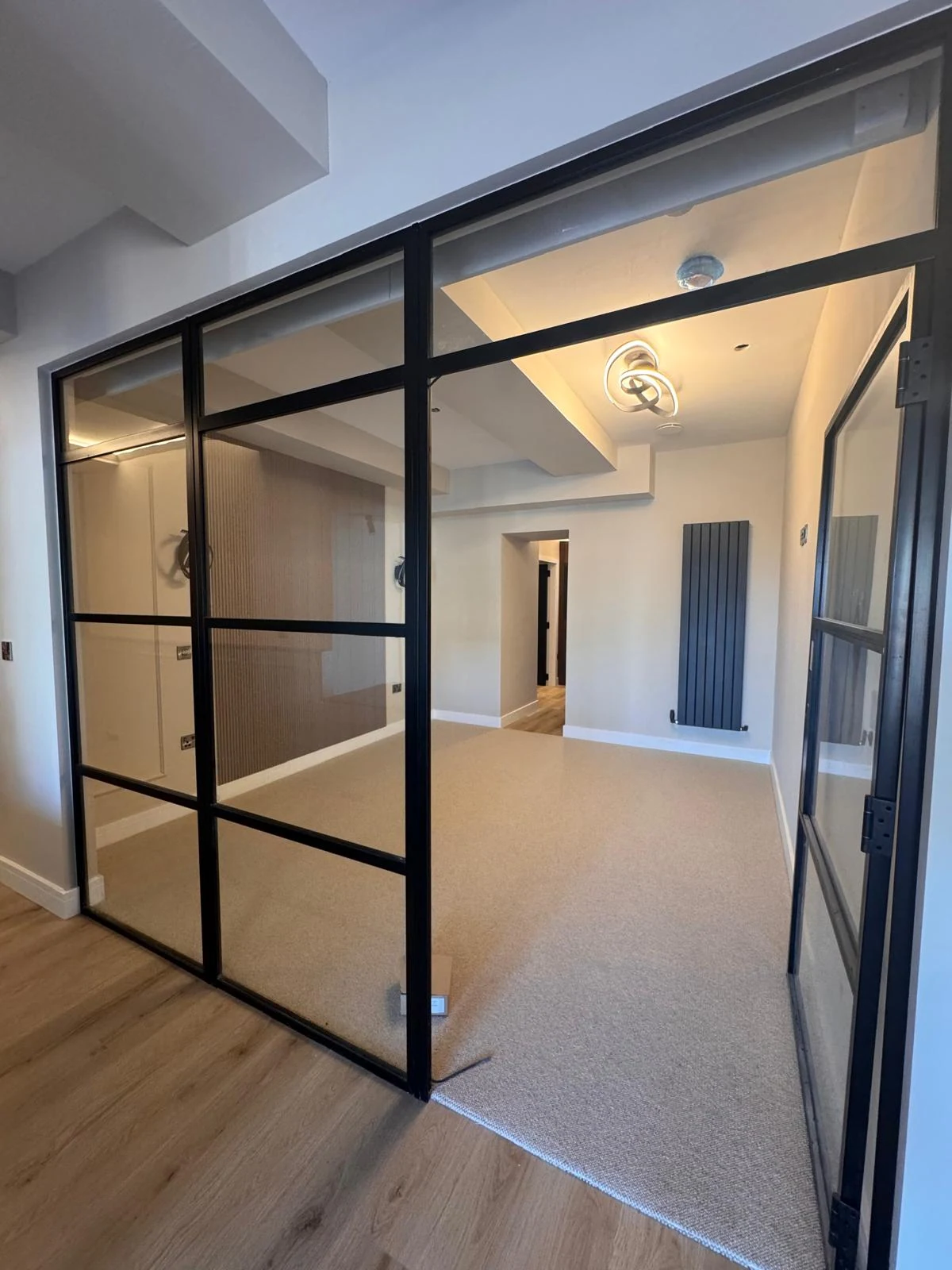 Black steel-framed glass partition room in a renovated home