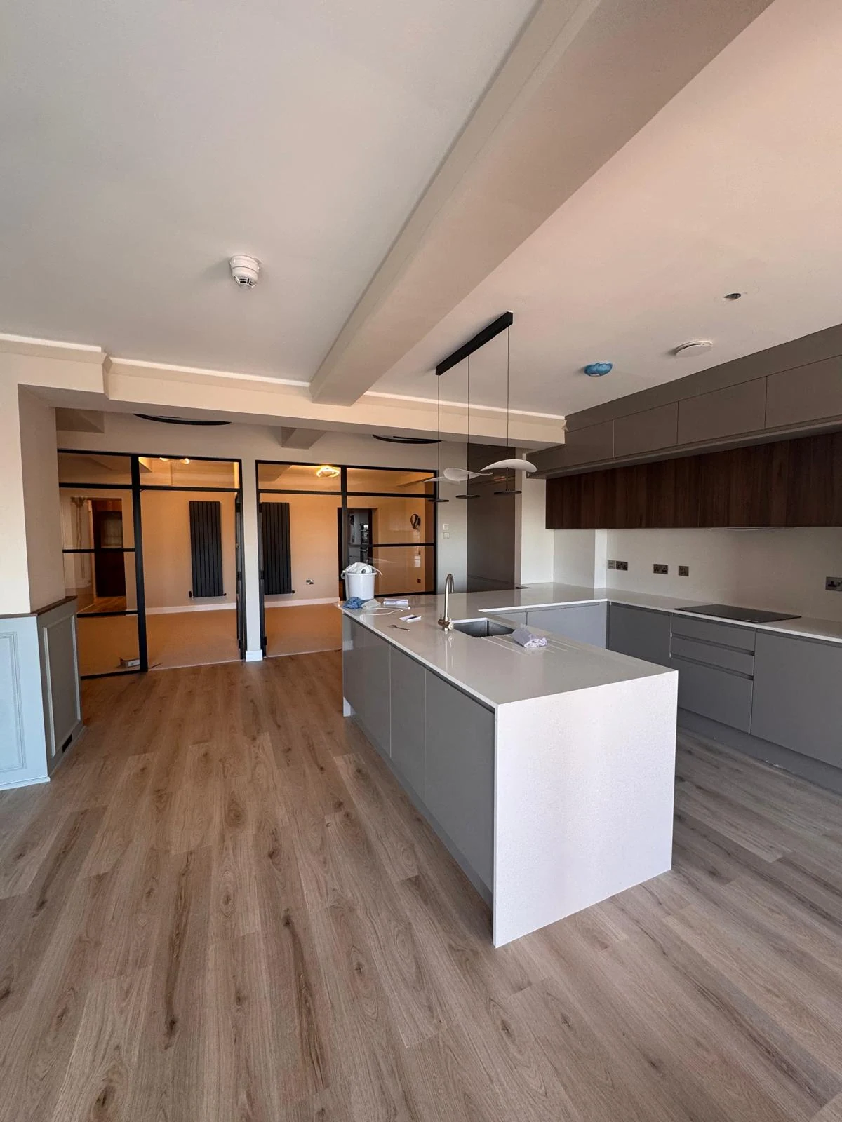 Finished kitchen with white island and dark timber units
